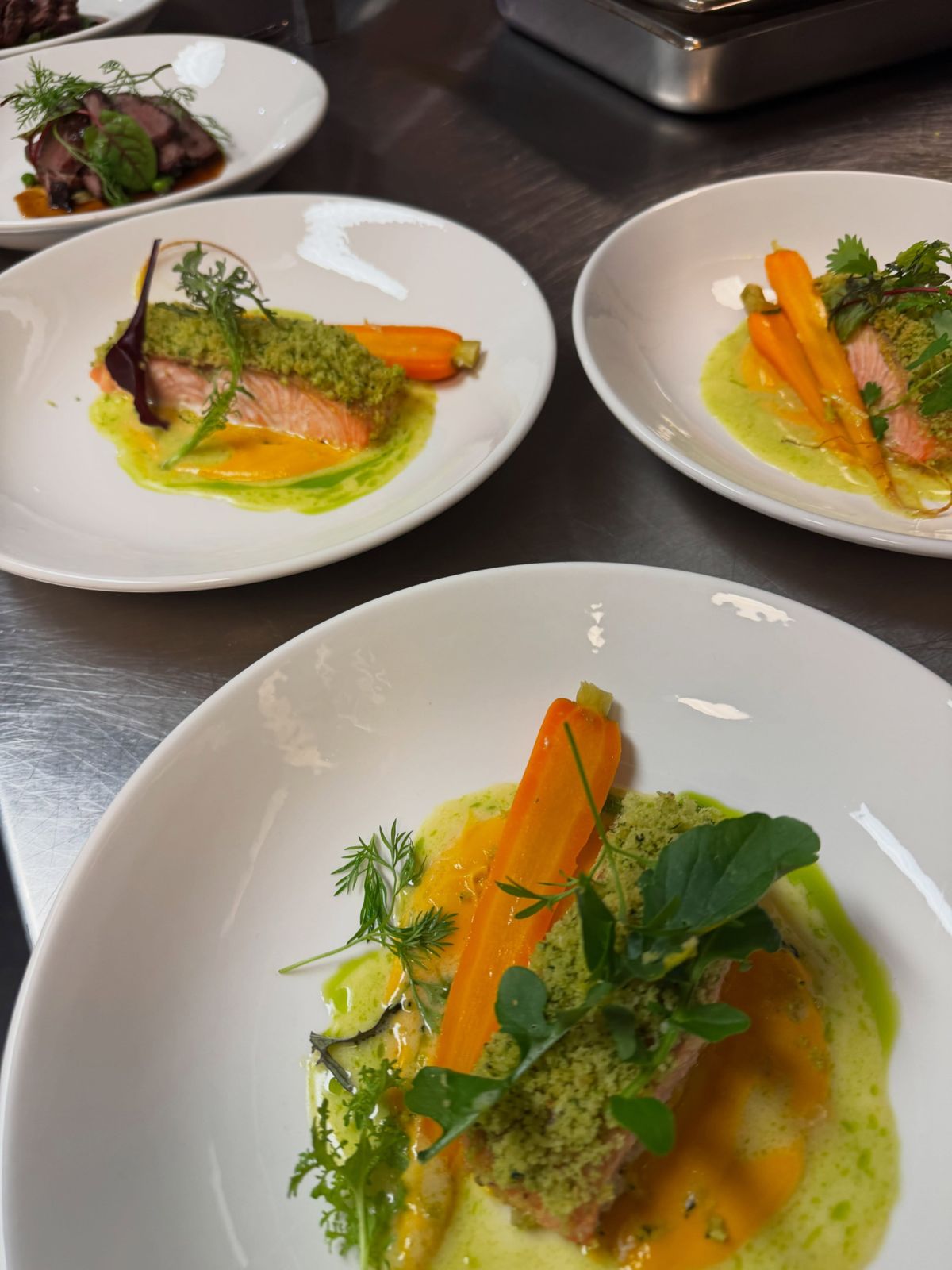 Plated salmon with heirloom carrots, herb crumb and green sauce