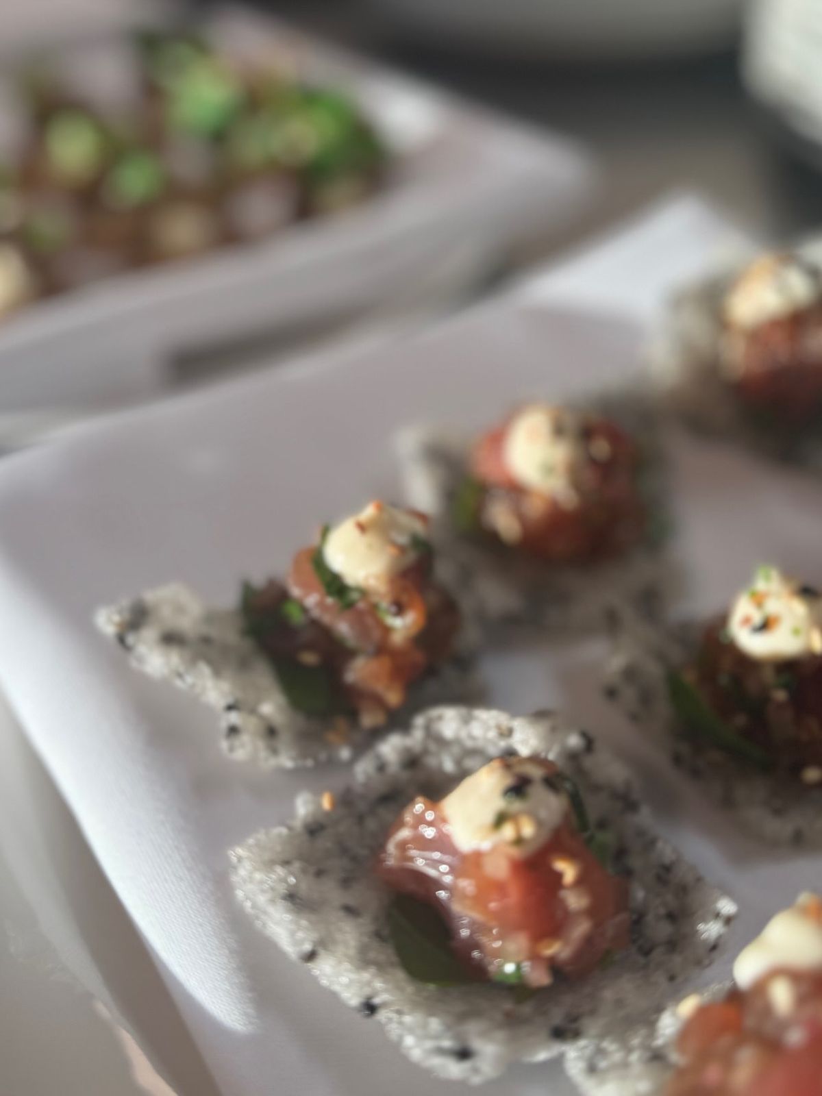 Cured salmon canapés on black sesame crisps